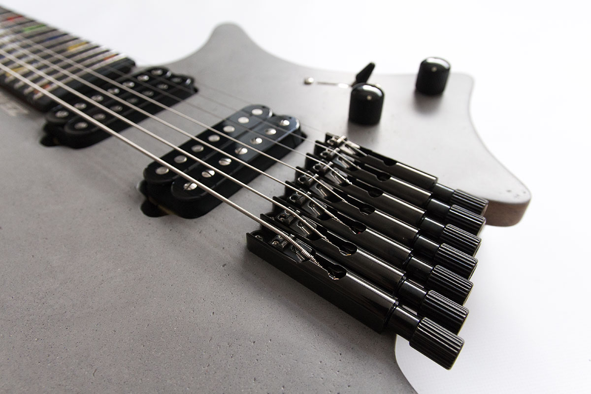 FK Custom Headless Fanned Fret Gitarre, Decke mit Beton Optik und schwarzer Hardware. Detailansicht Bridge.