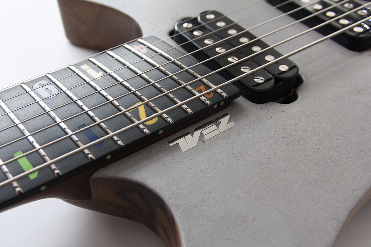 FK Custom Headless Fanned Fret Gitarre, Decke mit Beton Optik und schwarzer Hardware. Richlite Griffbrett mit bunten Zahlen als Inlays.
