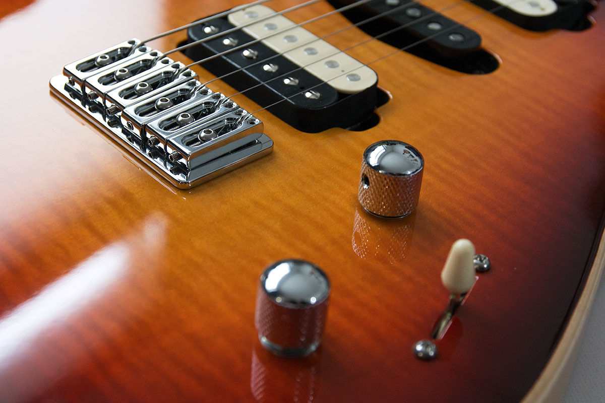 SK Custom Gitarre von Zeal Guitars. Ahorn Decke mit Cherry Sunburst Lackierung und einheimischen Hölzern. Detail Elektronik und ABM Bridge.