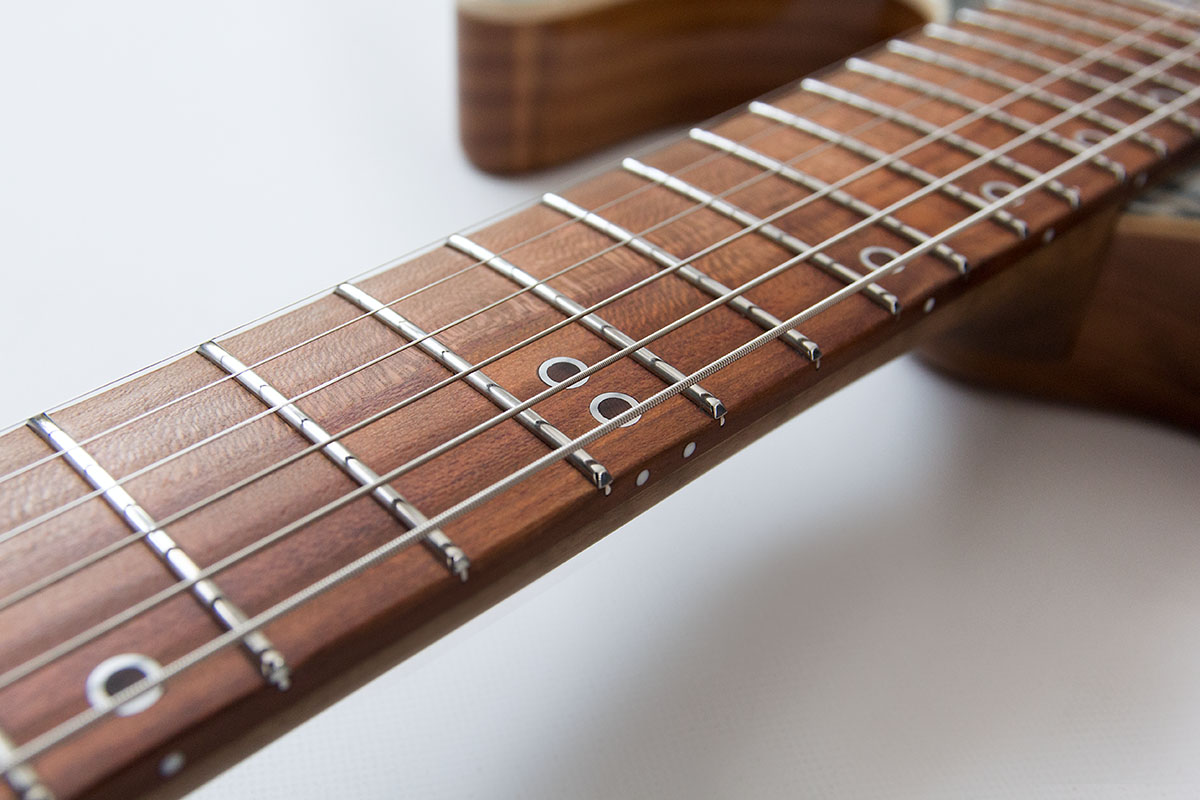 WF Custom 2, handgefertigte E-Gitarre. Detailansicht Pflaumengriffbrett mit Ring Inlays und Edestahlbünden.