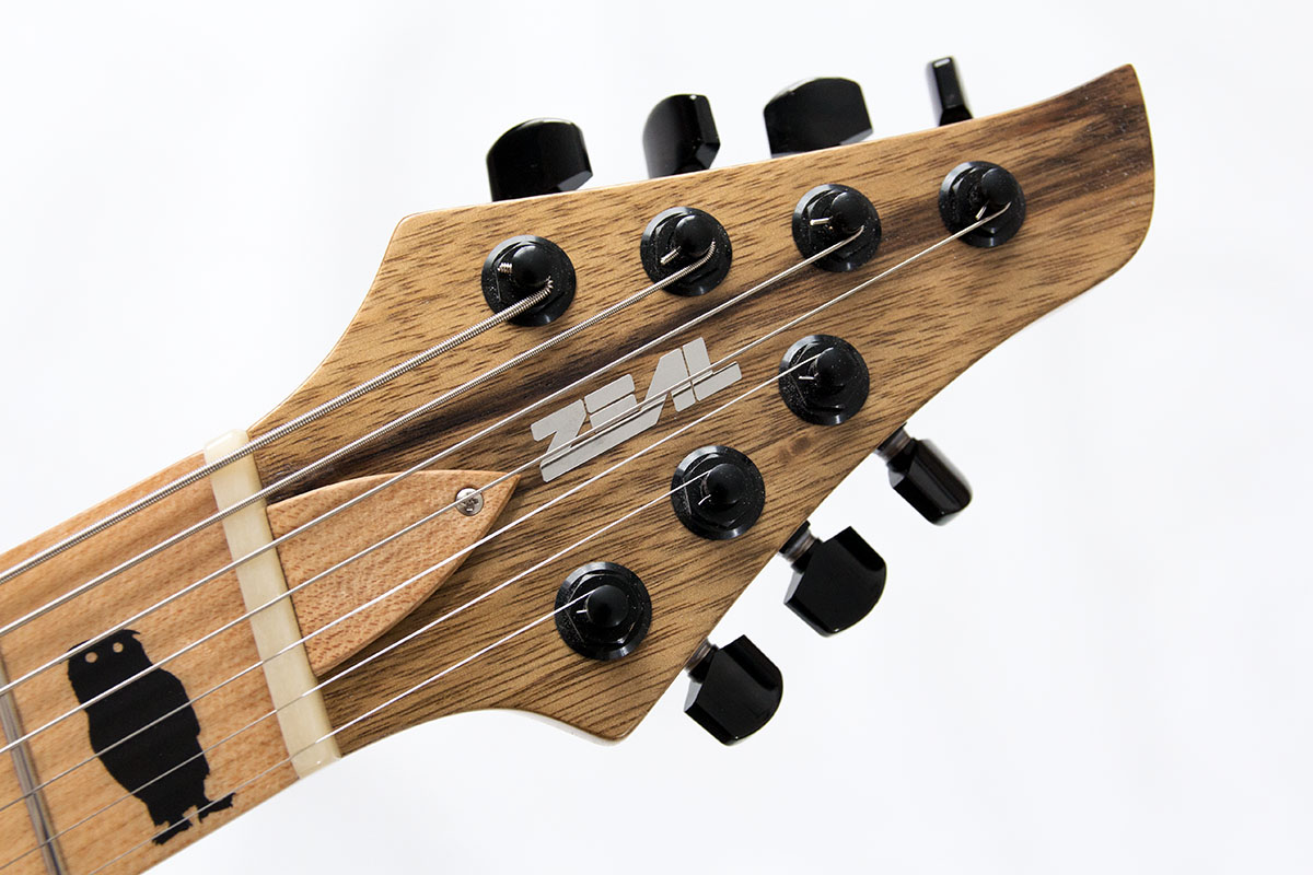 Hydra Multiscale JW Custom. 7-Saitige E-Gitarre mit Black Limba Body und Ahornhals. 2 Humbcuker und schwarze Hardware. Oberfläche geölt. Griffbrettgrafiken von Groot und schwarzen Vögeln.